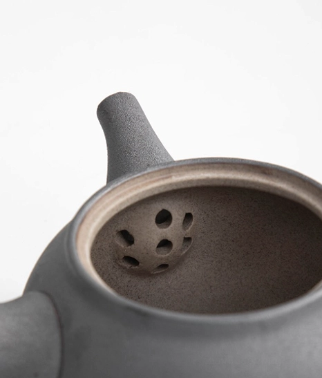side angle view of dark gray matte kyusu teapot with hammered texture