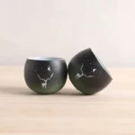 set of 2 gradient black green ceramic deer moon chinese tea cups on wood background