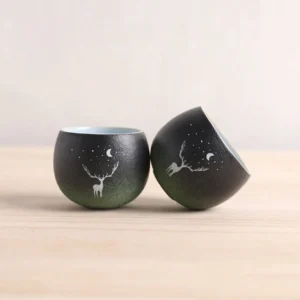 set of 2 gradient black green ceramic deer moon chinese tea cups on wood background