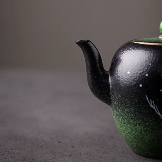 top view of black green ceramic teapot lid with green accent
