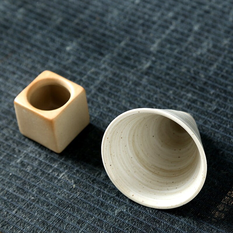 Detached cup and base of Japanese ceramic tea cup showing removable design