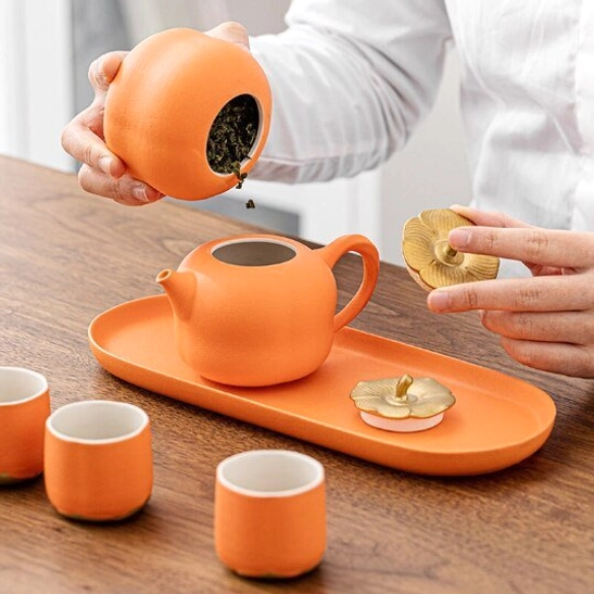full set of persimmon shaped tea pot with four cups on orange tray