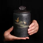 full side view of black gold ceramic crane tea canister