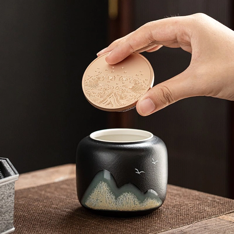 black ceramic tea storage canister with gold metal lid full view