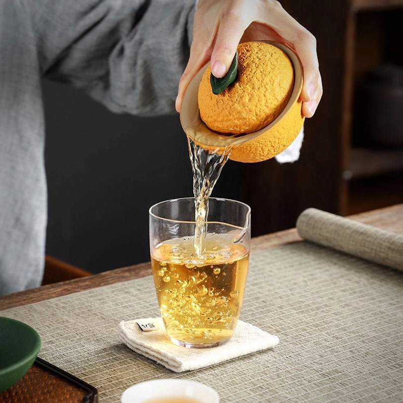 lid of orange citrus gaiwan tea cup with green leaf detail