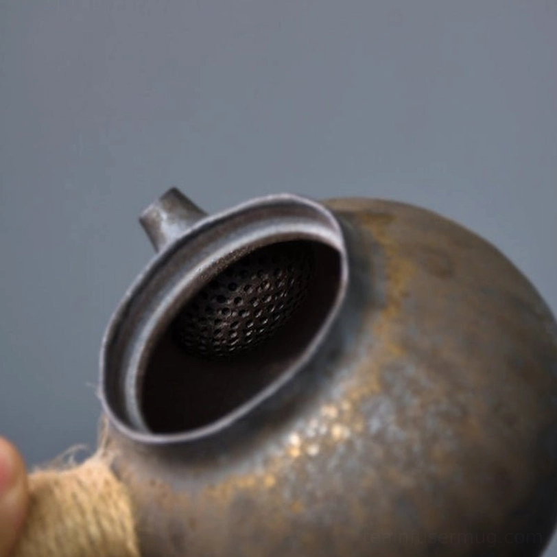 close up of built-in infuser inside gilded ceramic kyusu teapot