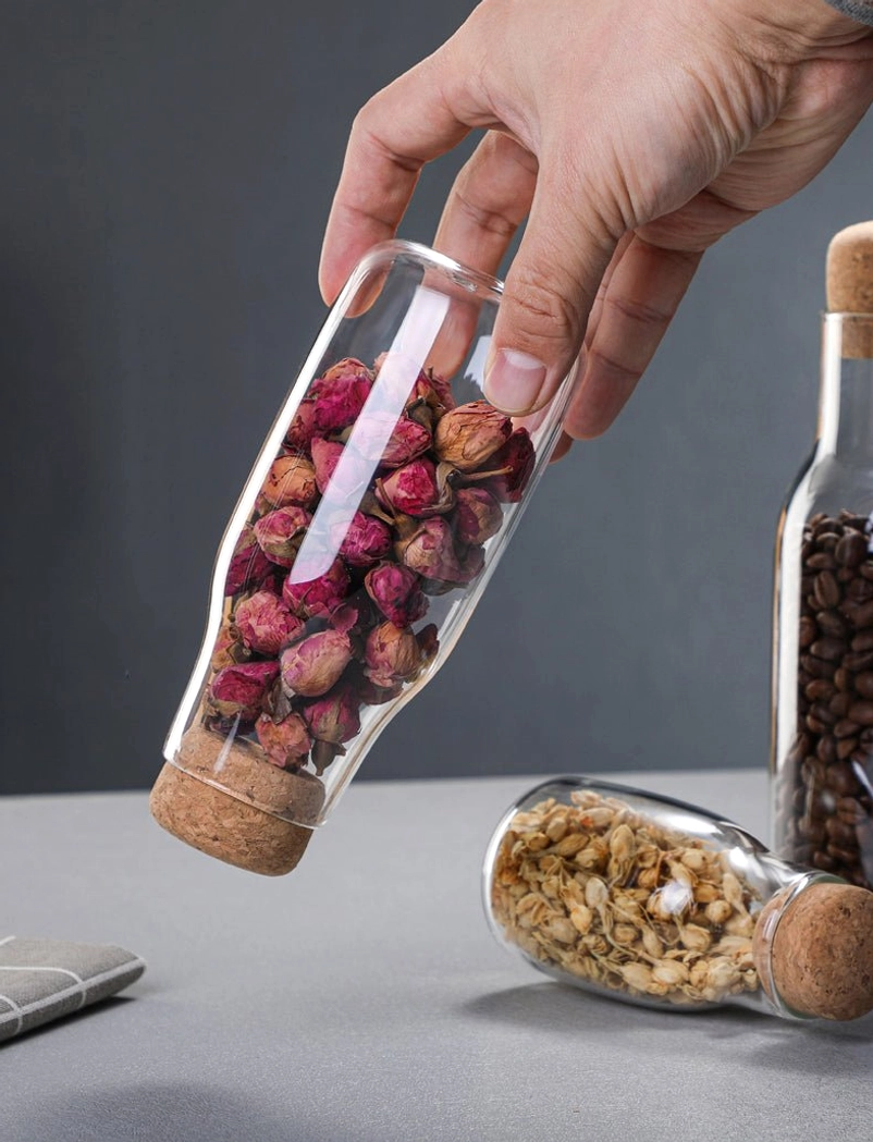glass tea storage canister holding dried flowers side view