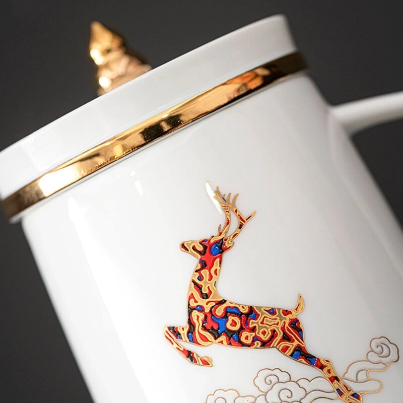 gold trimmed lid of ceramic tea infuser mug resting on wooden table