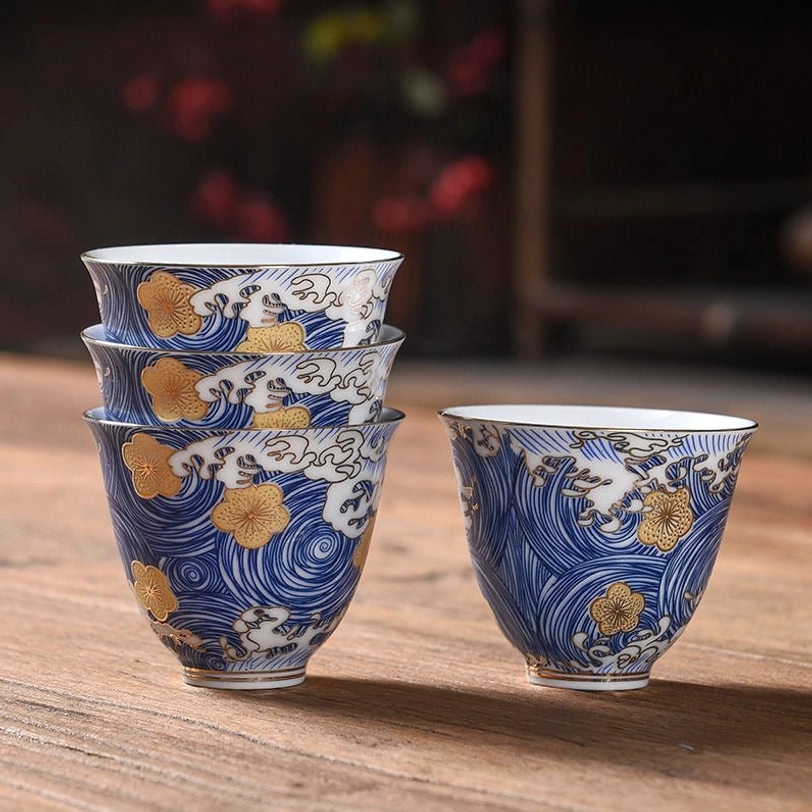 Blue gold Chinese porcelain tea cup close up of golden flower detail