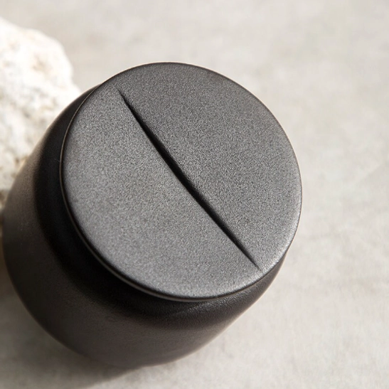 green ceramic tea storage canister placed on wooden tea table
