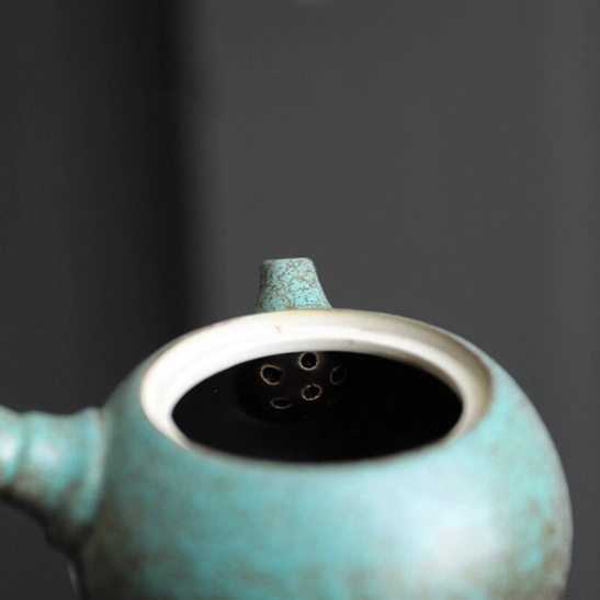 open green kyusu teapot showing built-in infuser filter inside