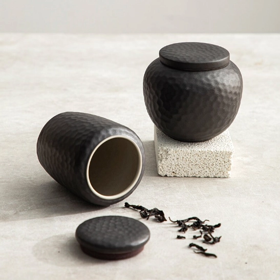 Hammered texture detail on black ceramic tea storage canister