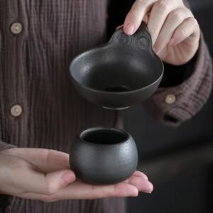 Hand-carved black ceramic tea strainer with stand full view