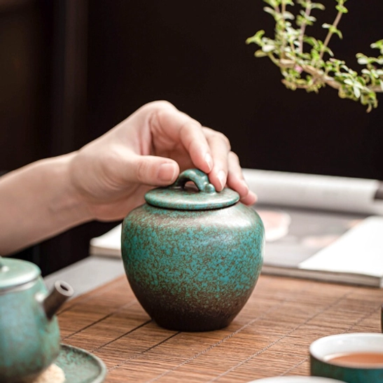 hand holding 300ml gradient ceramic tea canister side view