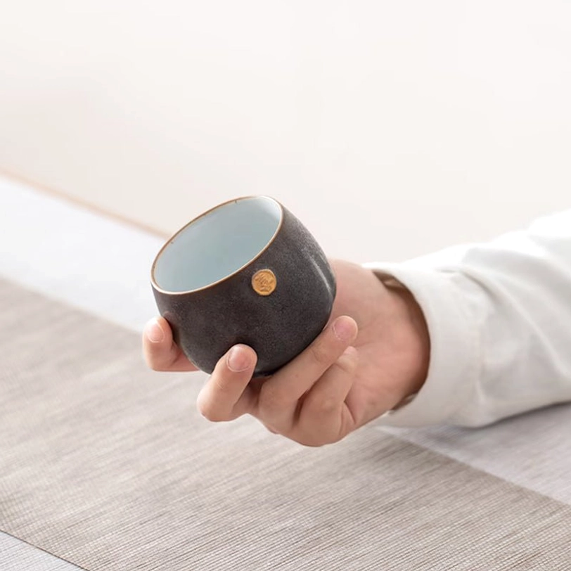 hand holding a chinese ceramic tea cup showing ergonomic fit