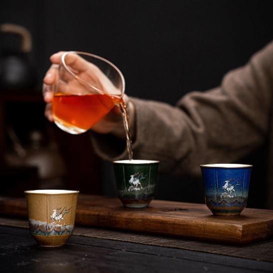 hand holding deer motif chinese tea cup showing ergonomic grip