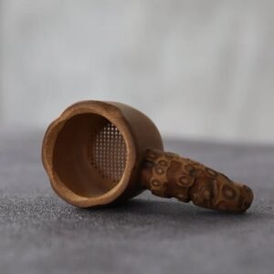 handmade natural bamboo root tea strainer resting on teapot