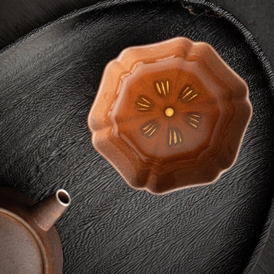 japanese clay tea cup filled with amber tea showing inner pattern