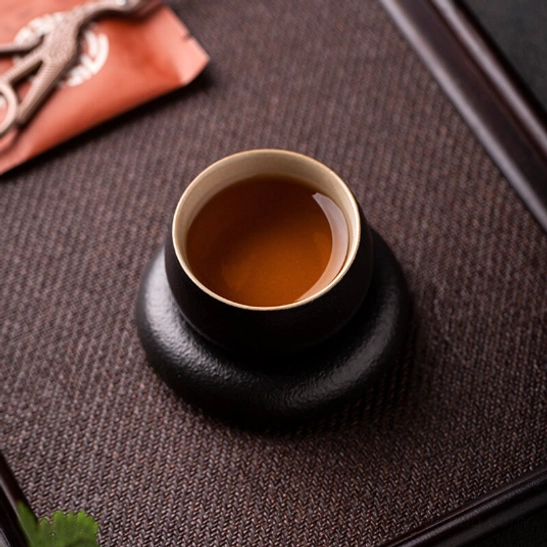 Bottom view of the matching black ceramic tea saucer