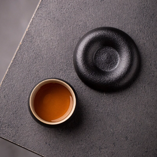 Close up of the small center detail on the matching black tea cup saucer