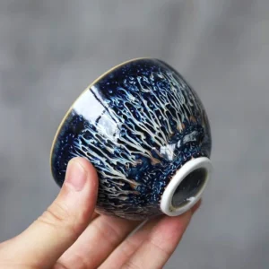 starry sky jian zhan tea cup held in hand showing glaze detail