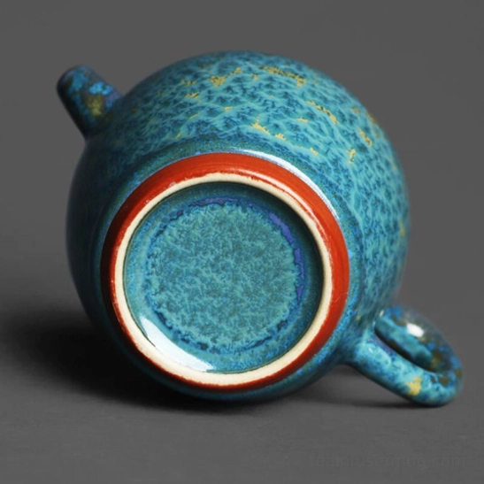top down view of open jun kiln turquoise blue teapot with infuser