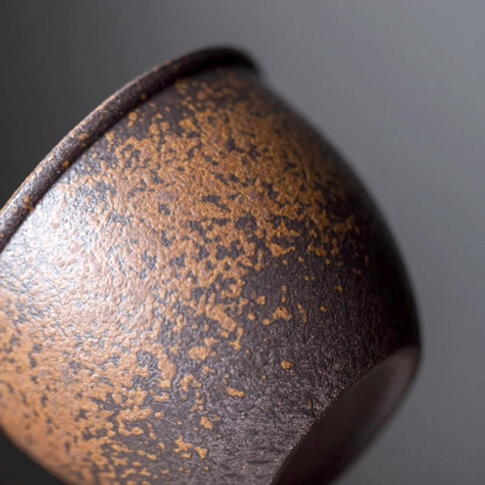 Iron rust glaze tea cup with tea leaves for size reference