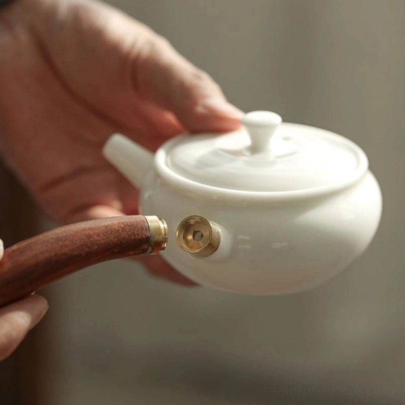 close up of the wooden side handle and brass connector of the kyusu teapot
