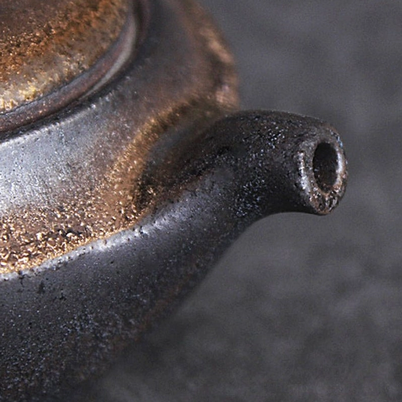 lid and vent of rustic gilded ceramic teapot with infuser