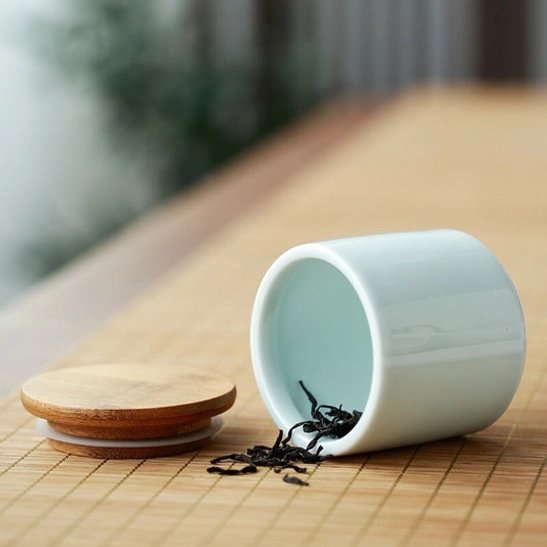 Loose leaf tea next to ceramic tea storage container