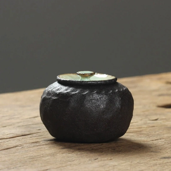 ceramic tea storage canister displayed with loose tea leaves