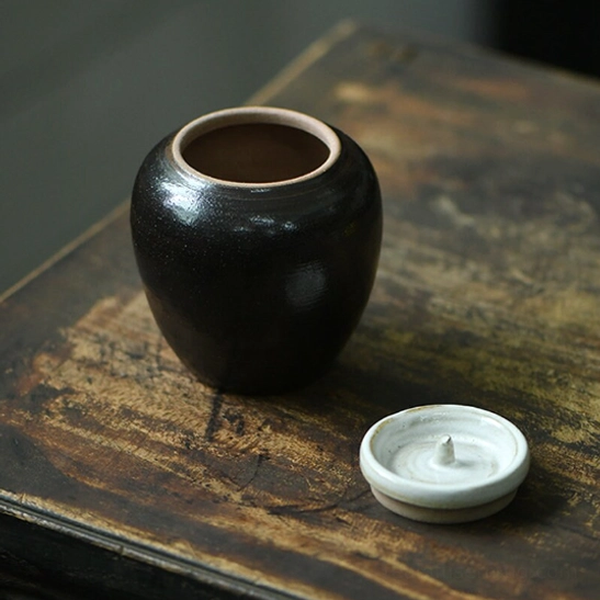 Size comparison of mini ceramic tea storage canister to show compact dimensions