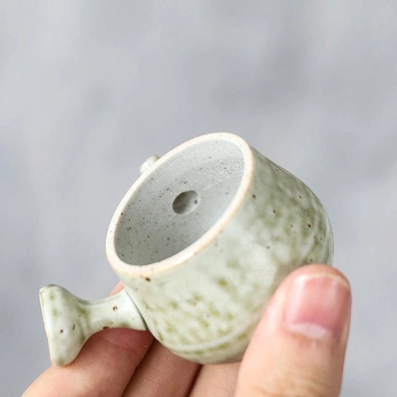 mini ceramic teapot displayed on wooden tea table