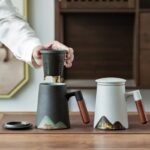 14oz ceramic mountain infuser tea mug with lid and wooden handle, both color variants displayed