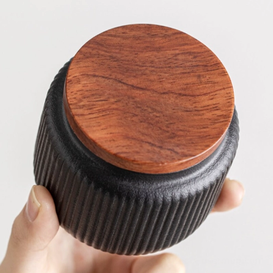 open ceramic tea storage canister holding loose leaf tea