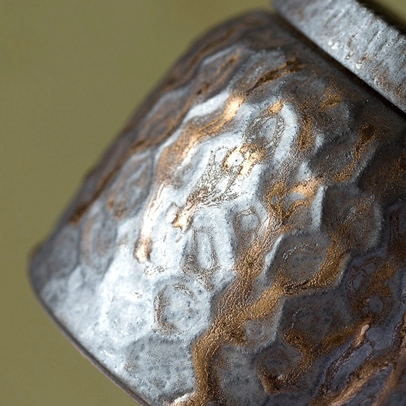 hammered ceramic tea canister open with loose tea poured out