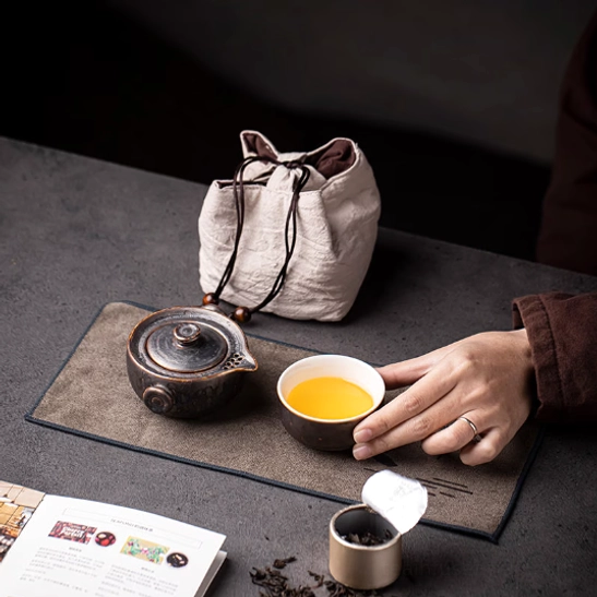 Packed travel tea set inside cotton storage bag