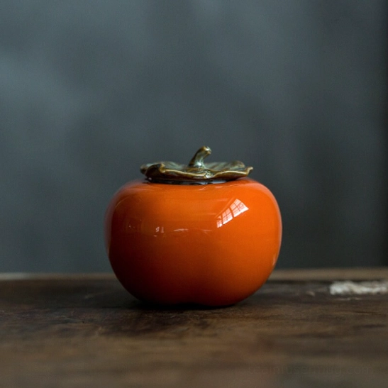 Persimmon ceramic tea storage canister placed on wooden tea table