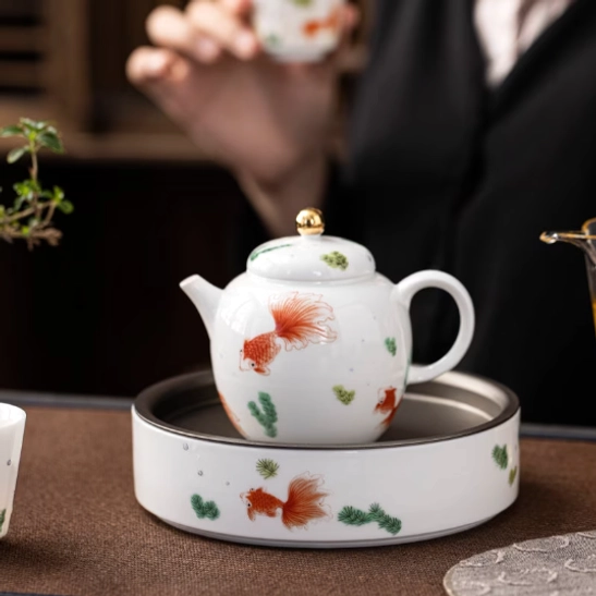 perspective view of koi fish ceramic teapot with infuser