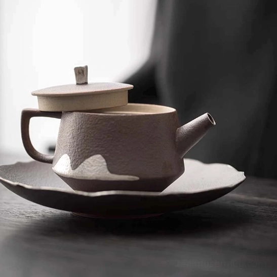 pouring brewed tea from faraway mountain ceramic teapot into cup