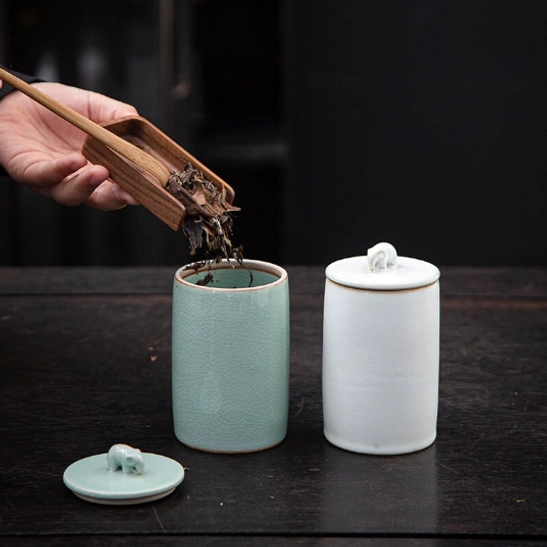 Purple ceramic tea storage canister with elephant handle on wood table