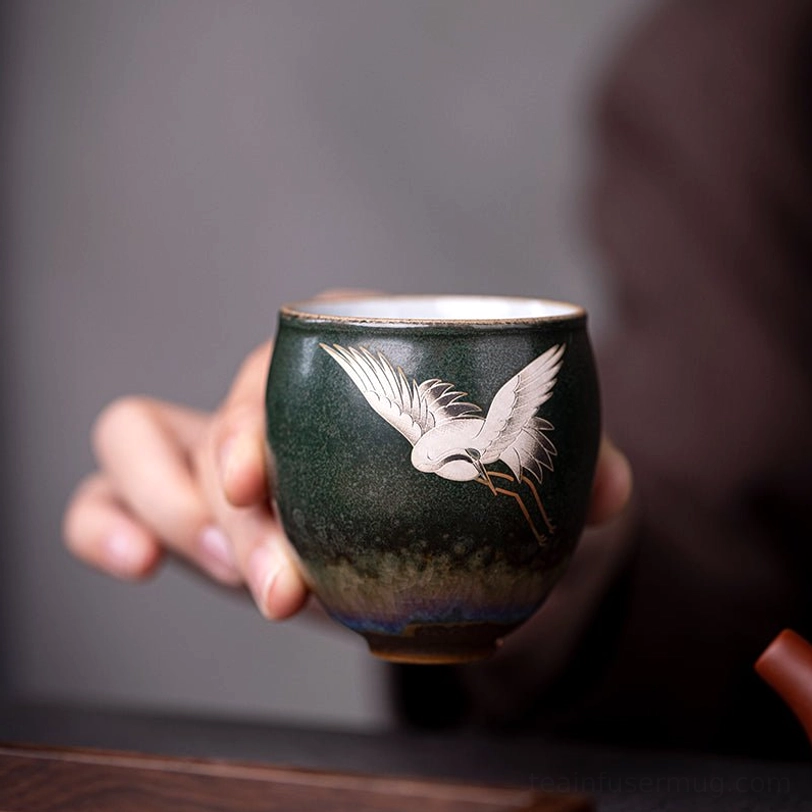 crane motif detail on red vintage chinese ceramic crane tea cup