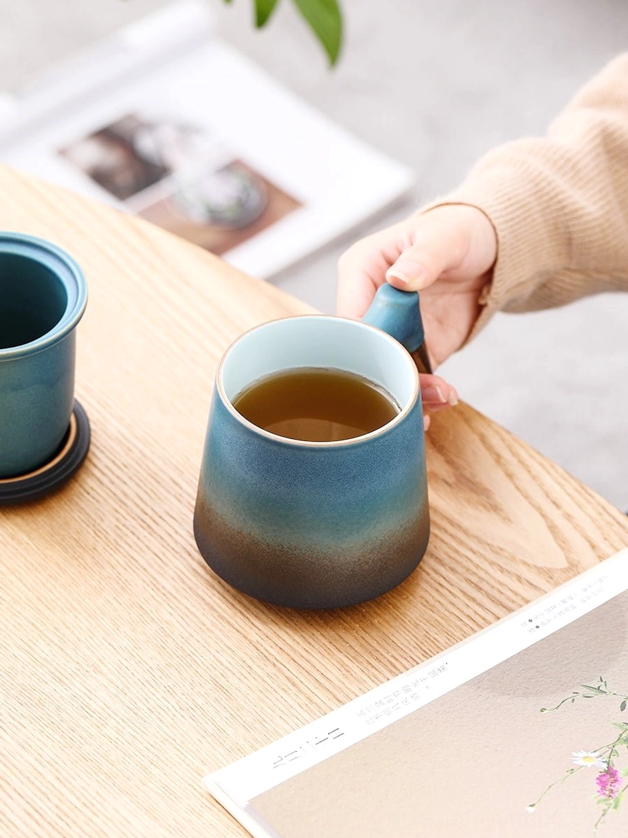 removable ceramic tea infuser resting on mug lid for draining