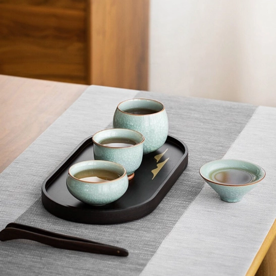 ru kiln ice crackle tea cup on a wooden tea table with tea set