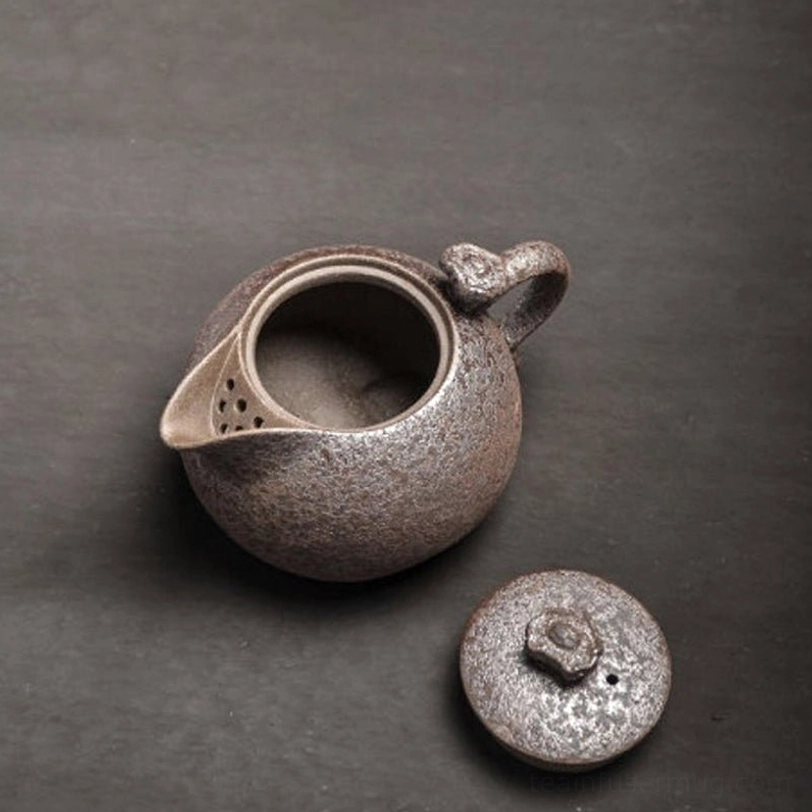 close up of built-in infuser filter holes inside rust glaze teapot