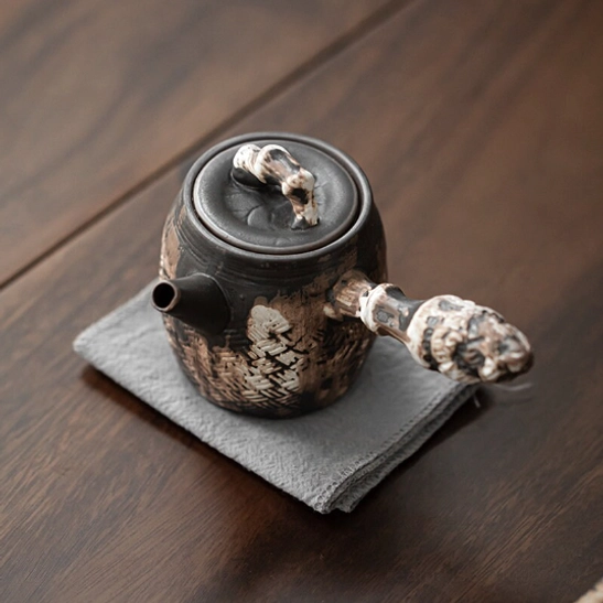 textured ceramic side handle teapot with infuser close up