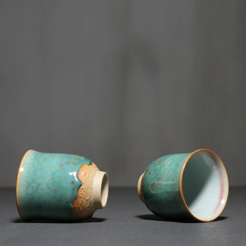 side view of green glaze porcelain teacup with golden speckles