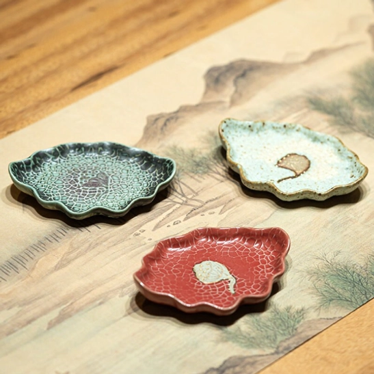 side view of ceramic lotus tea cup resting on matching leaf saucer