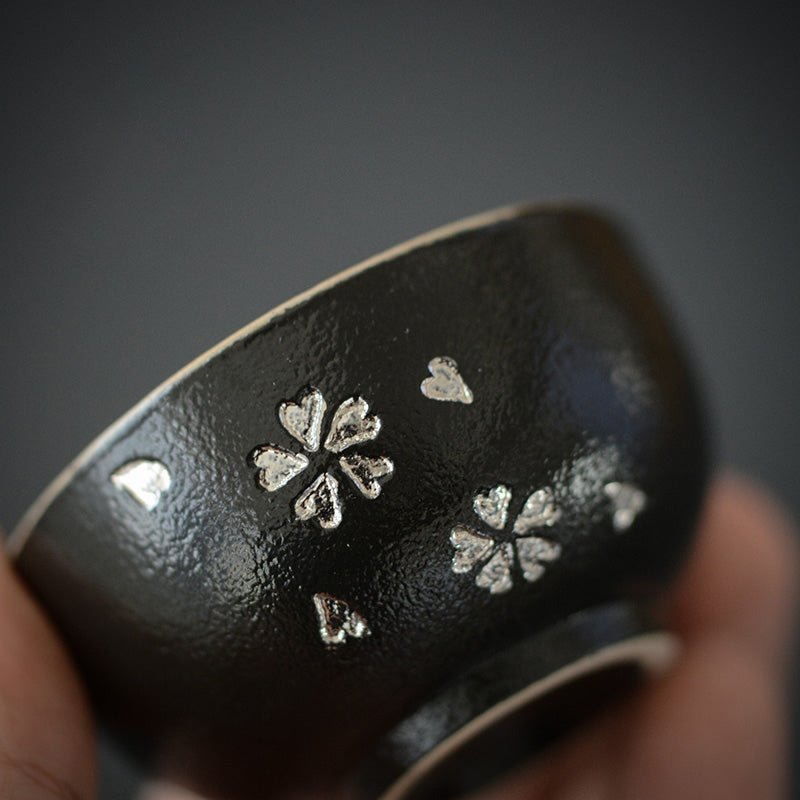 side view of two black japanese tea bowls showing outer textured finish