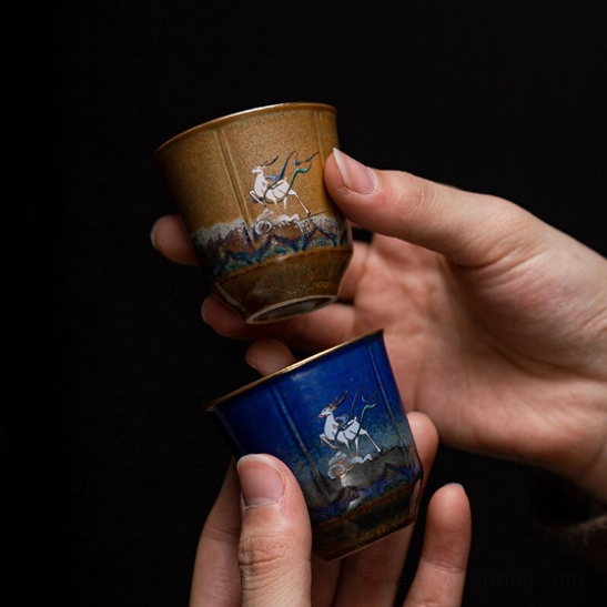 single dark blue chinese deer motif ceramic tea cup on white background